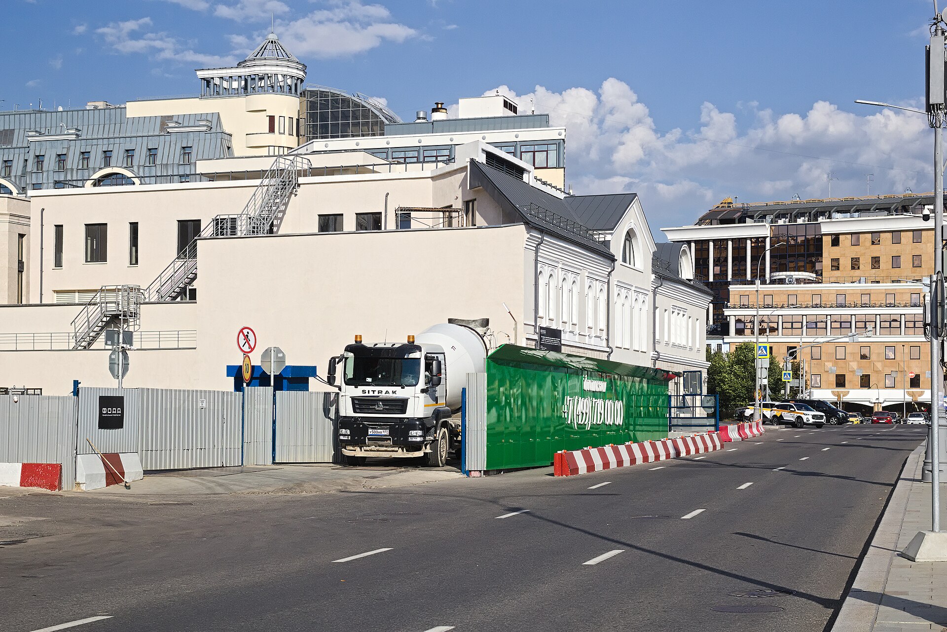 Автобетоносмеситель SITRAK C7H с зеленым барабаном миксера на городской улице