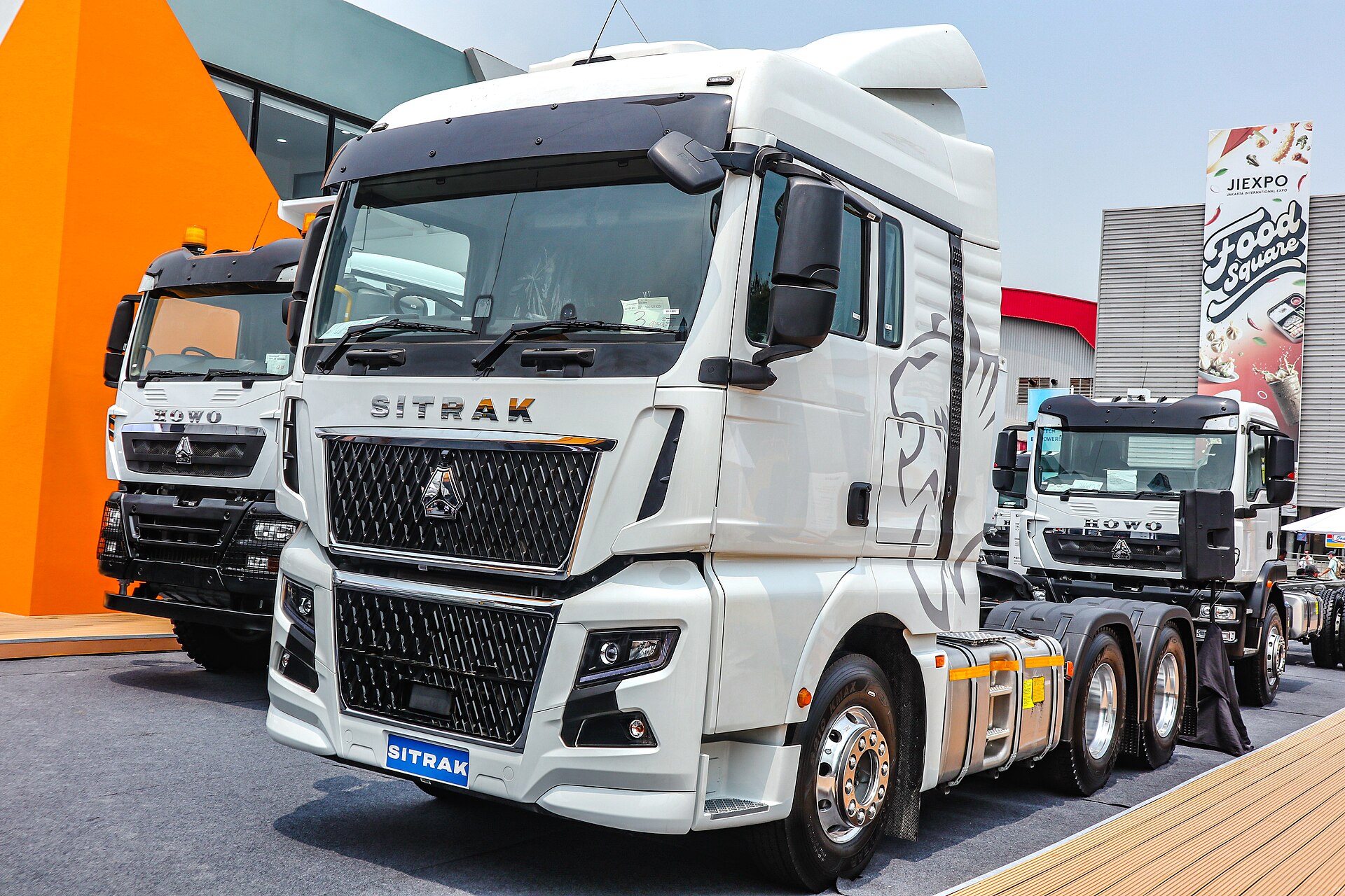 Белый седельный тягач SITRAK C7H с высокой кабиной, ракурс спереди и сбоку
